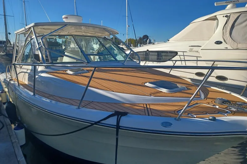 Slide: The Image of 2006 Rampage 33 Express boat docked at marina, featuring sleek design and wooden deck. - 4
