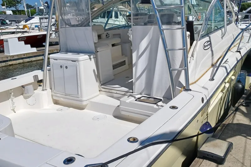 Slide: The Image of 2006 Rampage 33 Express boat docked, showcasing spacious deck and seating area. - 7