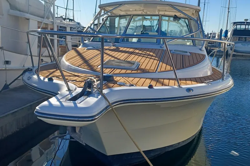 Slide: The Image of 2006 Rampage 33 Express boat docked, featuring sleek design and wooden deck. - 3