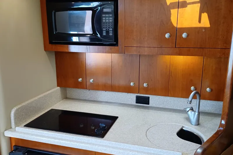 Slide: The Image of 2006 Rampage 33 Express yacht kitchen with microwave, stove, and wooden cabinets. - 10