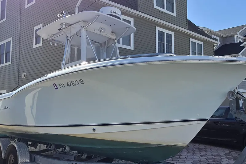 Slide: The Image of 2008 Sea Hunt Ultra 232 boat on trailer, parked near residential buildings. - 23