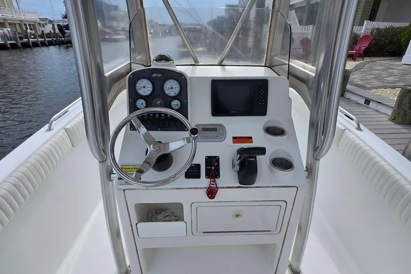 Slide: The Image of 2008 Sea Hunt Ultra 232 boat interior with white cushioned seating and cup holders. - 9