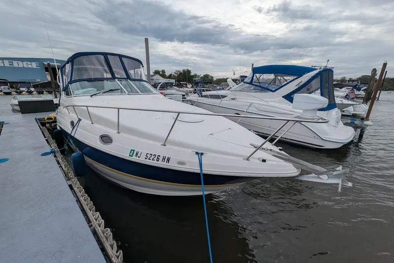 Slide: The Image of 2004 Cruisers Yachts 280 CXi Express docked at marina under cloudy sky. - 1