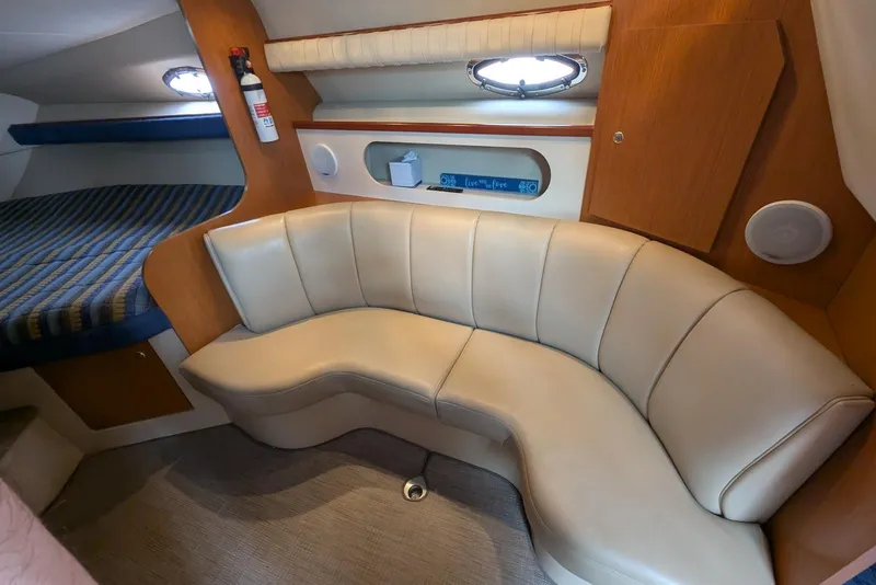 Slide: The Image of 2004 Cruisers Yachts 280 CXi Express cabin with beige leather seating and wood accents. - 6