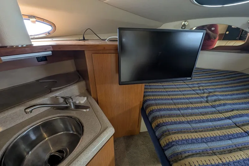 Slide: The Image of Interior of 2004 Cruisers Yachts 280 CXi Express with sink, TV, and bed. - 7