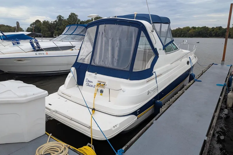 The Image of 2004 Cruisers Yachts 280 CXi Express docked, featuring blue canopy and white hull. - 0
