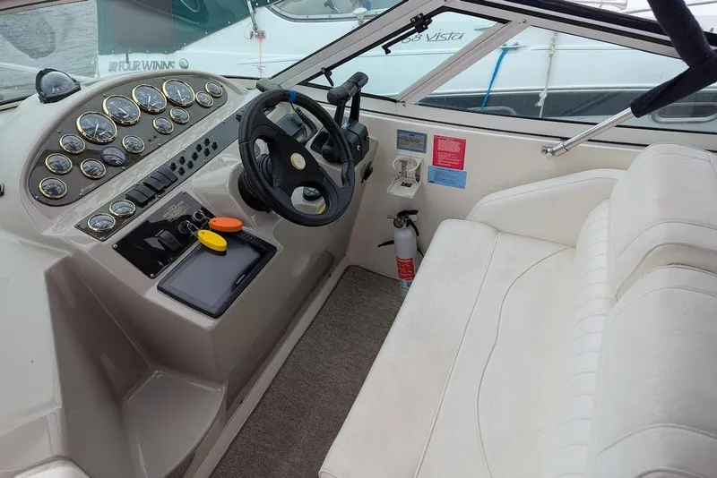 Slide: The Image of 2004 Cruisers Yachts 280 CXi Express helm with gauges, steering wheel, and seating. - 3