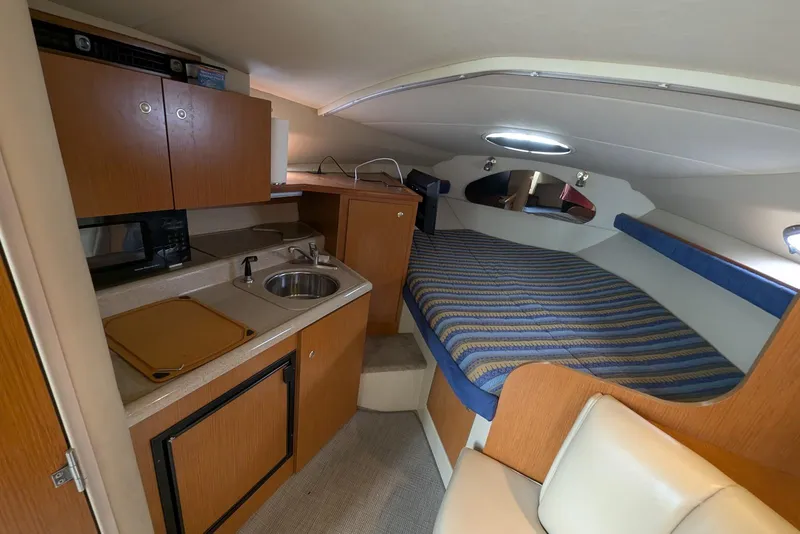 Slide: The Image of 2004 Cruisers Yachts 280 CXi Express cabin with kitchenette and cozy sleeping area. - 5