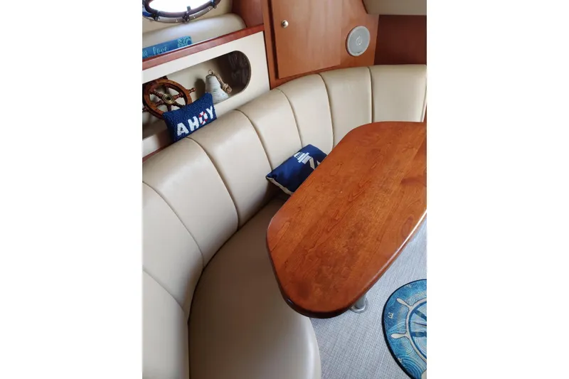 Slide: The Image of 2004 Cruisers Yachts 280 CXi Express interior with beige seating and wooden table. - 9