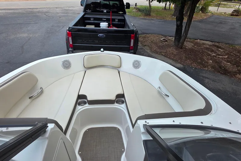 Slide: The Image of 2019 Bayliner VR4 Bowrider I/O interior with beige seating, parked near a black pickup truck. - 12