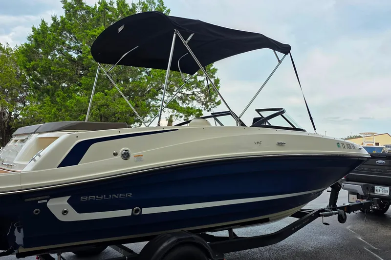 Slide: The Image of 2019 Bayliner VR4 Bowrider I/O boat with canopy on trailer, parked outdoors. - 2