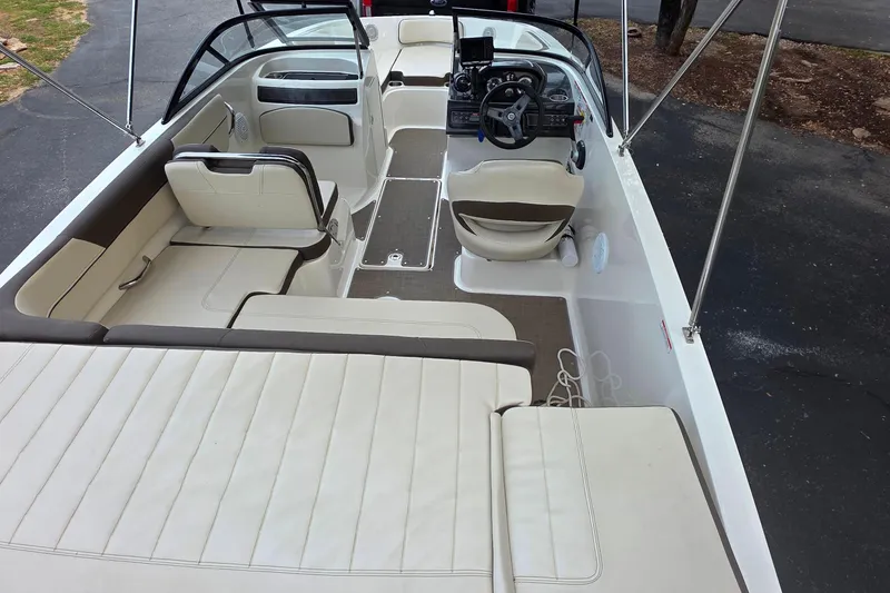 Slide: The Image of 2019 Bayliner VR4 Bowrider I/O interior with seating and steering wheel, parked on pavement. - 6