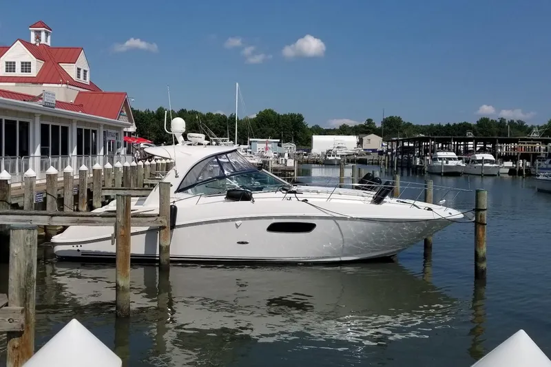 Slide: The Image of 2009 Sea Ray 350 Sundancer docked at a marina under a clear blue sky. - 2