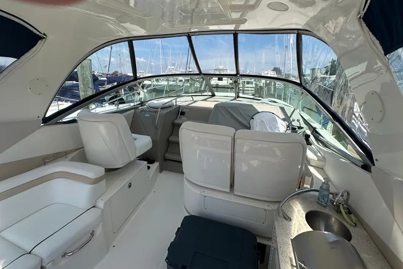 Slide: The Image of Interior of 2009 Sea Ray 350 Sundancer yacht with helm, seating, and kitchenette. - 3