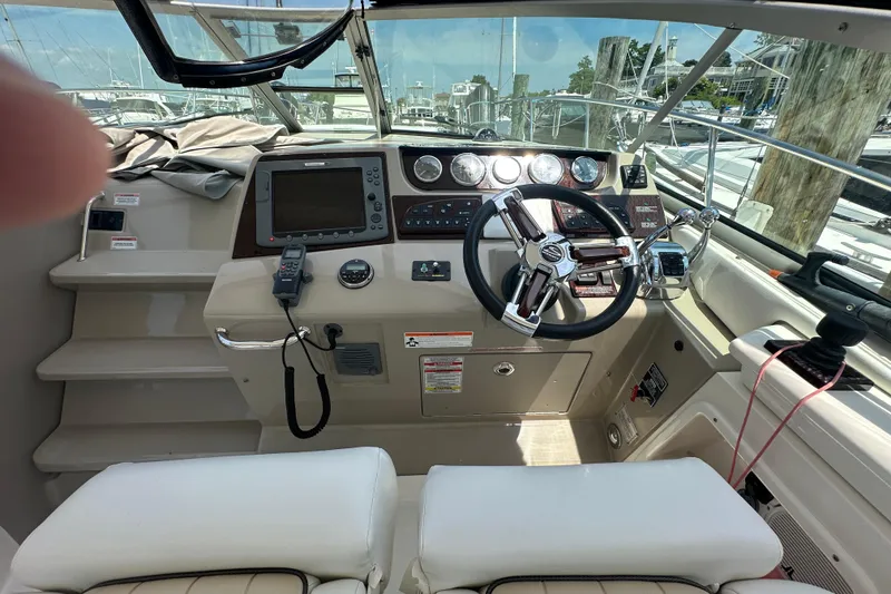 Slide: The Image of 2009 Sea Ray 350 Sundancer helm with steering wheel, navigation controls, and gauges. - 4
