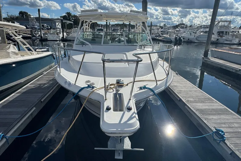 Slide: The Image of 2015 Wellcraft 290 Coastal boat docked at marina under cloudy sky. - 2