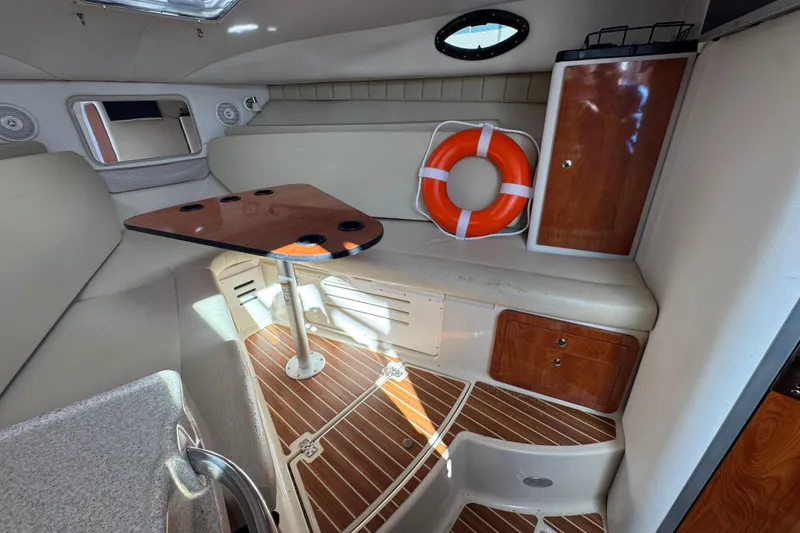 Slide: The Image of 2015 Wellcraft 290 Coastal cabin interior with table, seating, and life preserver. - 21