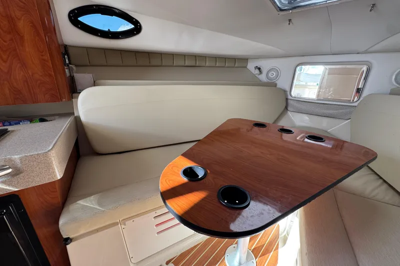 Slide: The Image of Interior of 2015 Wellcraft 290 Coastal boat with seating and wooden table. - 23