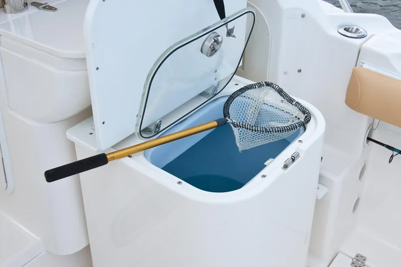 Slide: The Image of Manufacturer Provided Image: Open storage compartment with fishing net on 2015 Wellcraft 290 Coastal boat. - 26