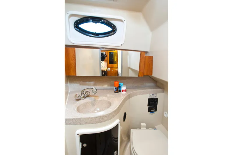 Slide: The Image of Manufacturer Provided Image: 2015 Wellcraft 290 Coastal bathroom with sink, mirror, and porthole window. - 27