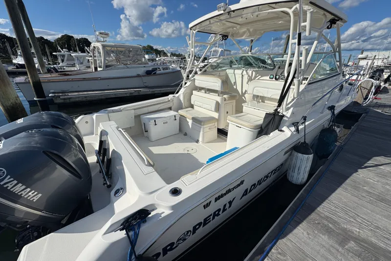 Slide: The Image of 2015 Wellcraft 290 Coastal boat docked, featuring Yamaha engines and spacious seating. - 3