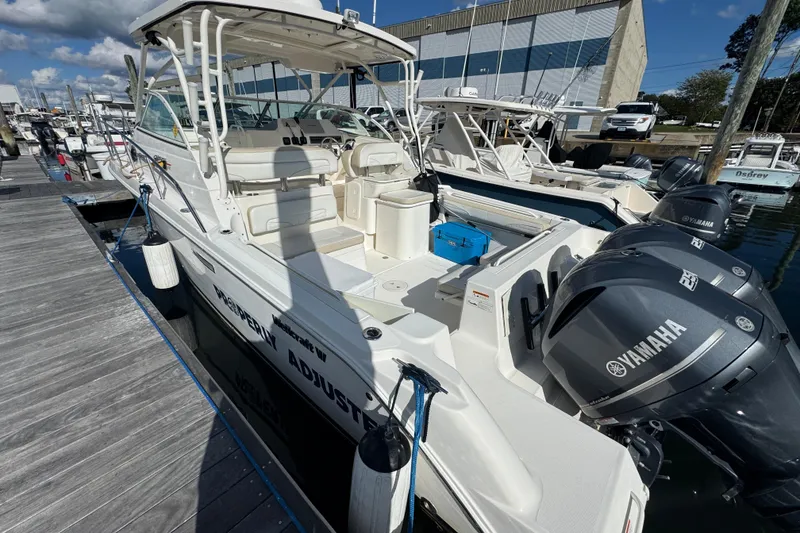 Slide: The Image of 2015 Wellcraft 290 Coastal boat docked, featuring Yamaha engines and spacious seating area. - 4