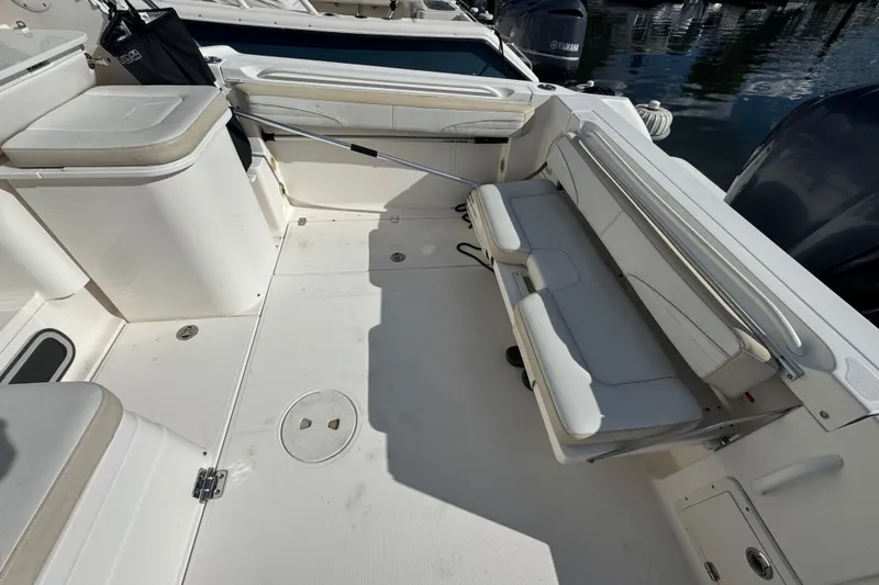 Slide: The Image of 2015 Wellcraft 290 Coastal boat interior with white seating and storage compartments. - 7