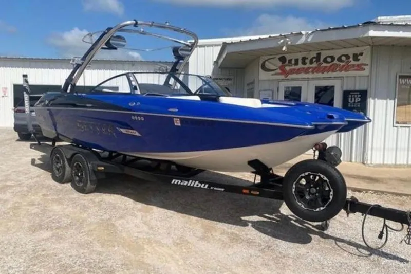 Slide: The Image of 2012 Malibu Wakesetter 22 MXZ boat on trailer outside dealership. - 3
