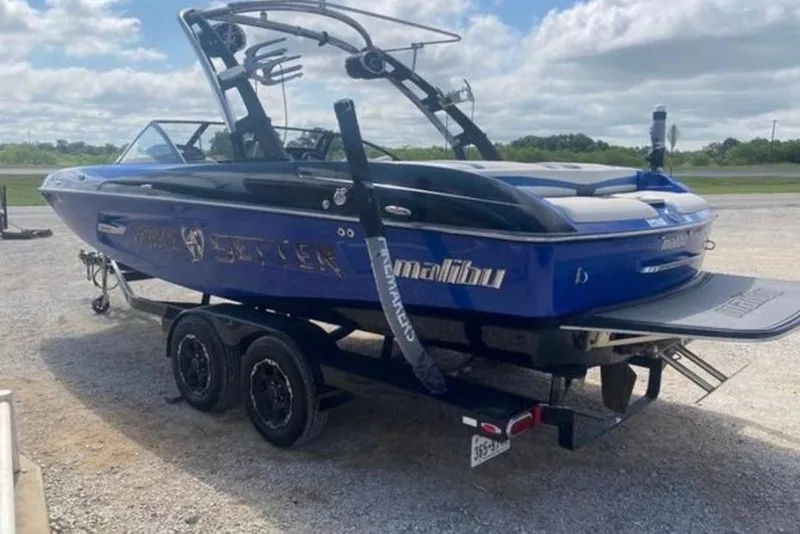 Slide: The Image of 2012 Malibu Wakesetter 22 MXZ boat on trailer, blue exterior, parked outdoors. - 9