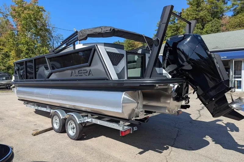 Slide: The Image of 2026 Alera M23Q pontoon boat on trailer, featuring sleek design and powerful outboard motor. - 4