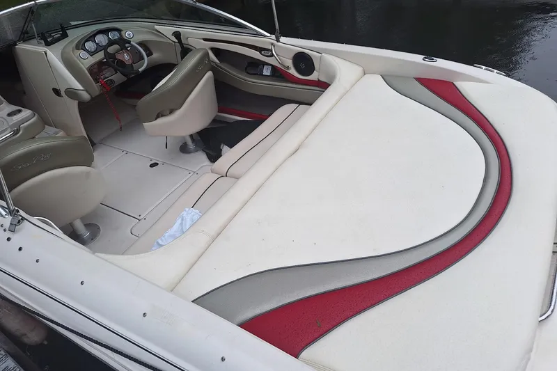 Slide: The Image of 2005 Sea Ray 220 Select boat interior with beige and red seating, dashboard, and steering wheel. - 18