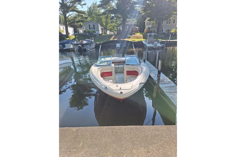 Slide: The Image of 2005 Sea Ray 220 Select boat docked in a serene lakeside setting. - 19