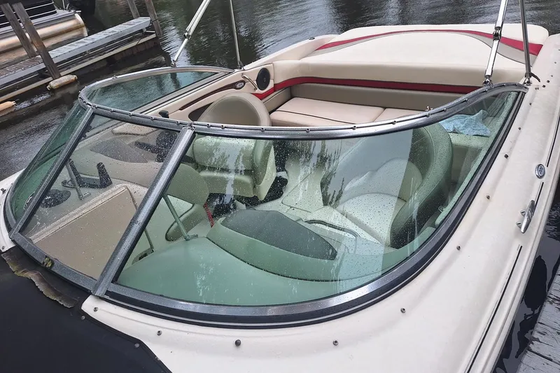 Slide: The Image of 2005 Sea Ray 220 Select boat with beige interior, docked on a calm waterway. - 20