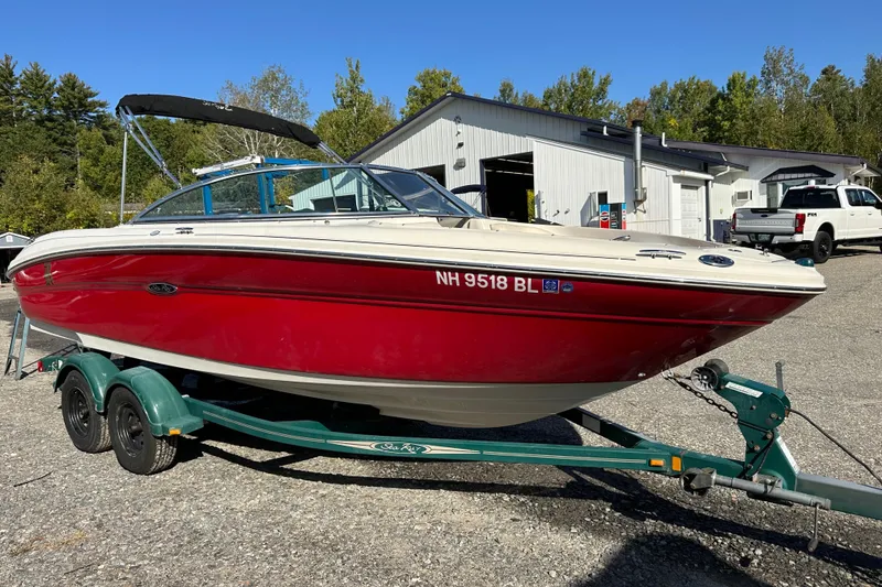 Slide: The Image of 2005 Sea Ray 220 Select boat on trailer, red hull, parked outdoors. - 4