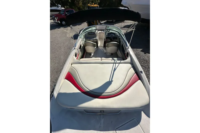 Slide: The Image of 2005 Sea Ray 220 Select boat interior with white and red seating, parked outdoors. - 6