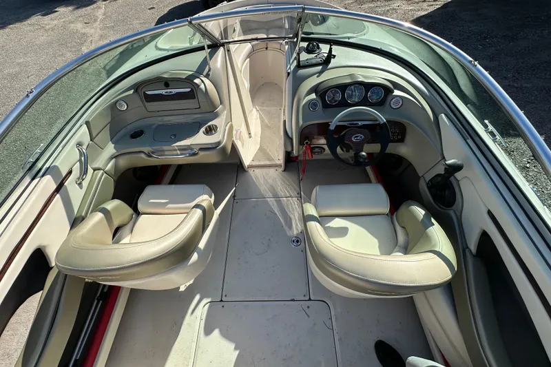 Slide: The Image of 2005 Sea Ray 220 Select boat interior with beige seating and dashboard controls. - 7
