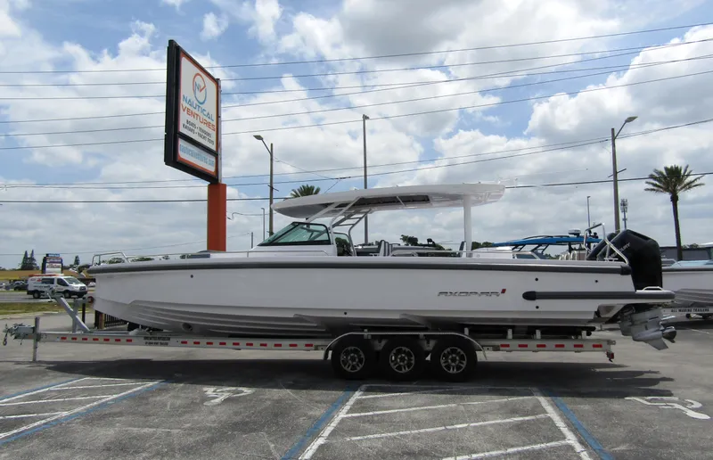 The Image of 2024 Axopar 37 Sun Top boat on a trailer in a parking lot. - 0