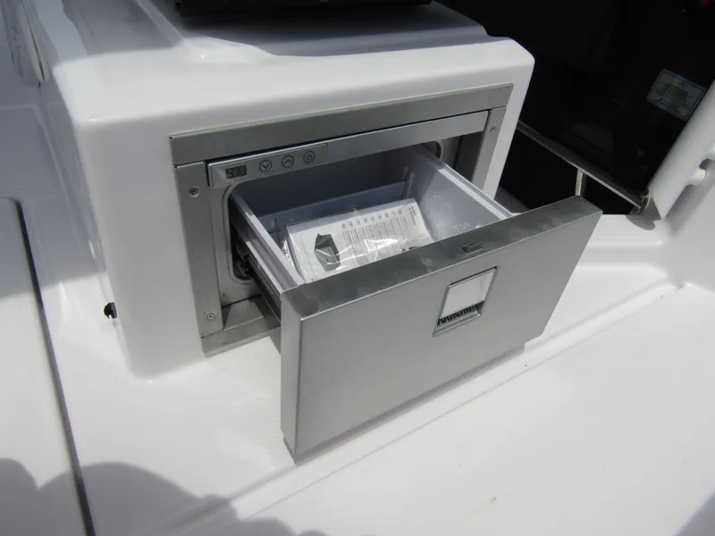 Slide: The Image of 2024 Axopar 37 Sun Top boat with an open stainless steel drawer refrigerator. - 19