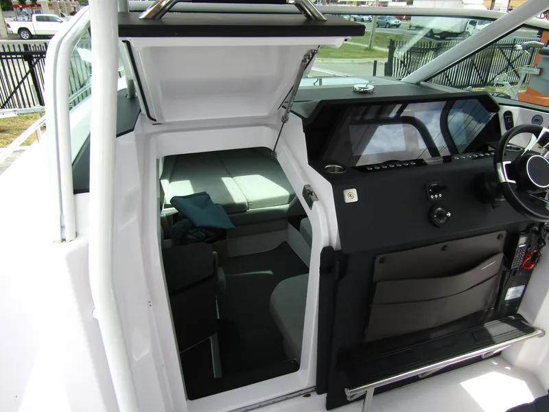 Slide: The Image of 2024 Axopar 37 Sun Top interior with helm and cabin view. - 20