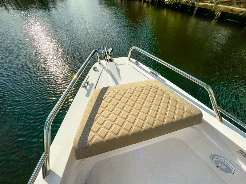 Slide: The Image of 2024 Axopar 37XC CROSS CABIN bow with cushioned seating on calm water. - 10