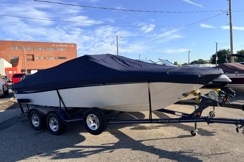 Slide: The Image of 2004 Four Winns 210 Horizon boat on trailer, covered, parked outdoors. - 10