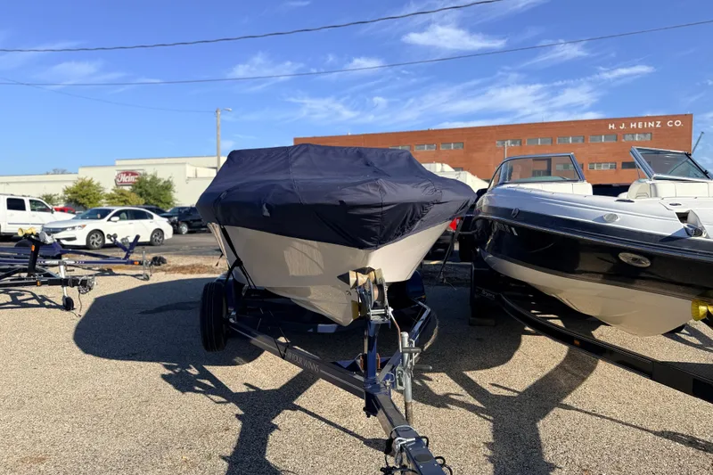 Slide: The Image of 2004 Four Winns 210 Horizon boat covered on trailer, parked outdoors. - 11