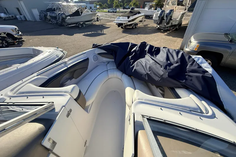 Slide: The Image of 2004 Four Winns 210 Horizon boat interior with cover, parked in a marina. - 19
