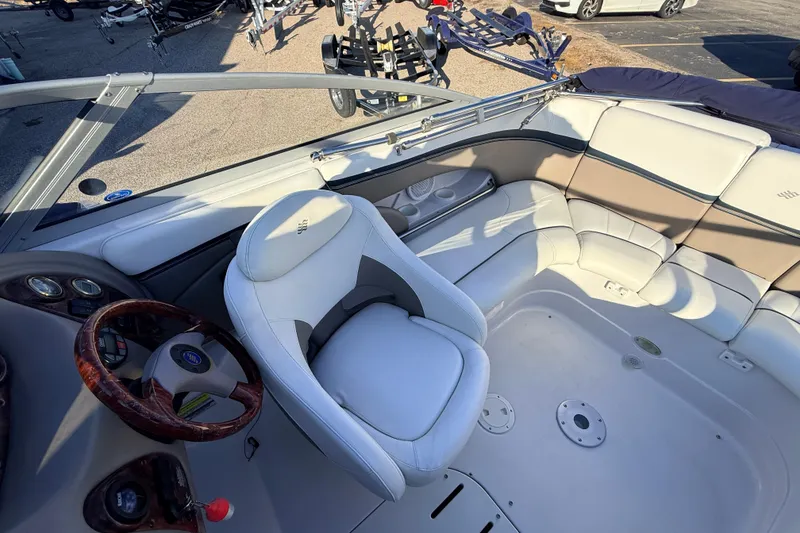 Slide: The Image of 2004 Four Winns 210 Horizon boat interior with white seating and wooden steering wheel. - 3