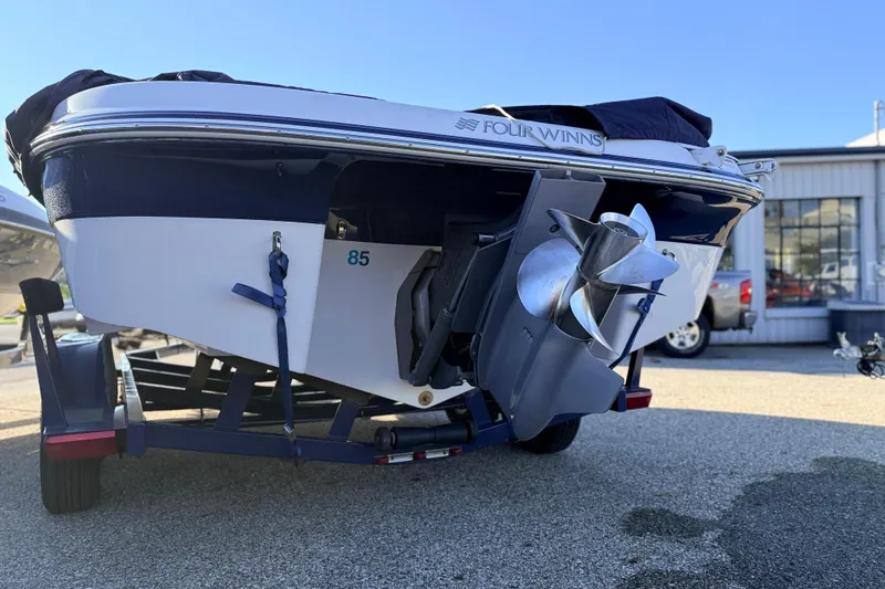 Slide: The Image of 2004 Four Winns 210 Horizon boat on trailer, rear view with propeller visible. - 33