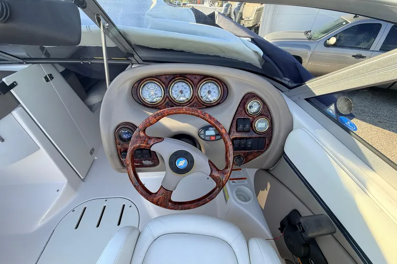 Slide: The Image of 2004 Four Winns 210 Horizon boat dashboard with wood-accented steering wheel and gauges. - 7