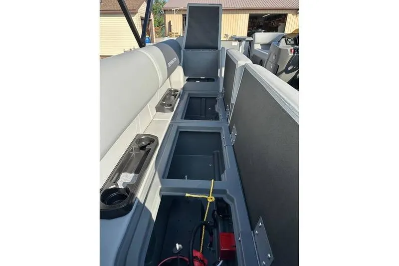 Slide: The Image of 2026 Bennington 23 SSR Quad Bench interior with open storage compartments and seating. - 17