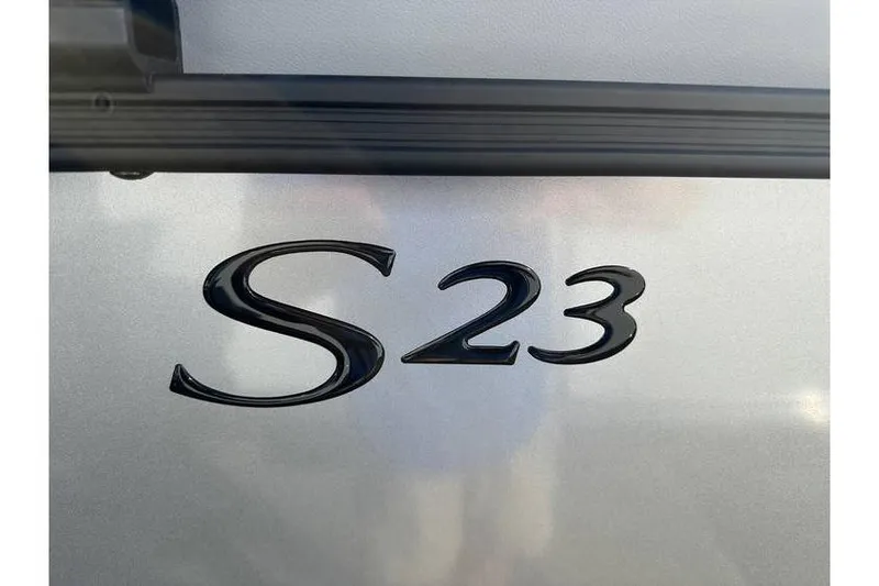 Slide: The Image of Close-up of 2026 Bennington 23 SSR Quad Bench model emblem on silver surface. - 3