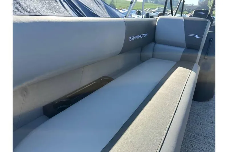 Slide: The Image of 2026 Bennington 23 SSR Quad Bench boat interior with gray seating and cup holder. - 8