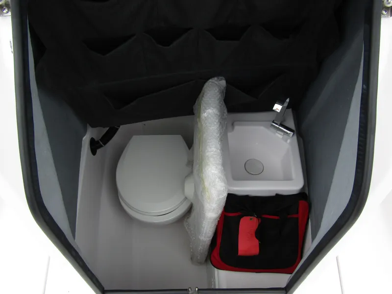 Slide: The Image of 2022 Axopar 22 T-Top boat interior with compact toilet and sink. - 11